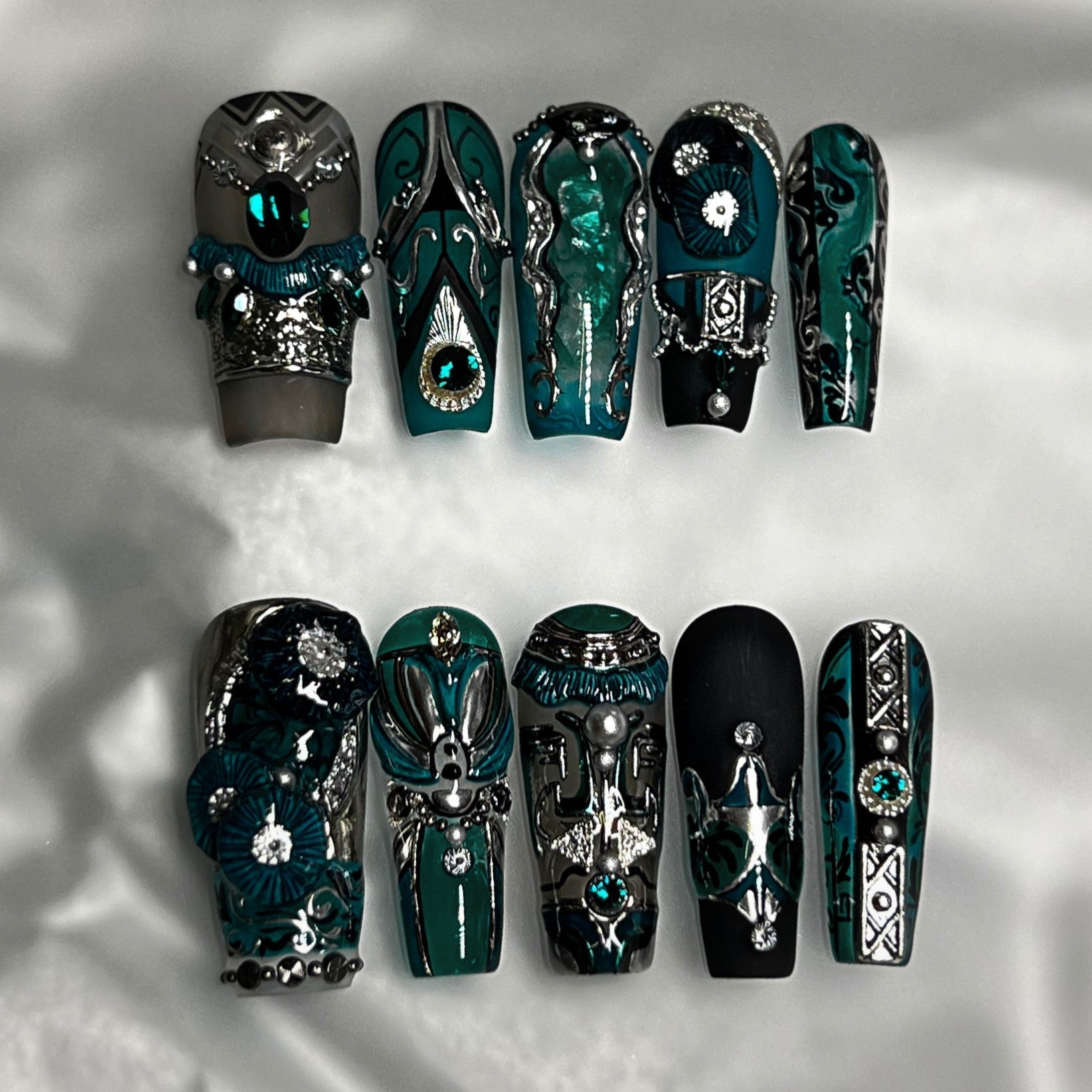 Intricately designed green and black nail art with a mix of textures